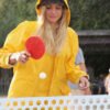 A woman playing table tennis on an outdoor table.