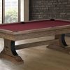 A wooden pool table with red felt set up in a large room.